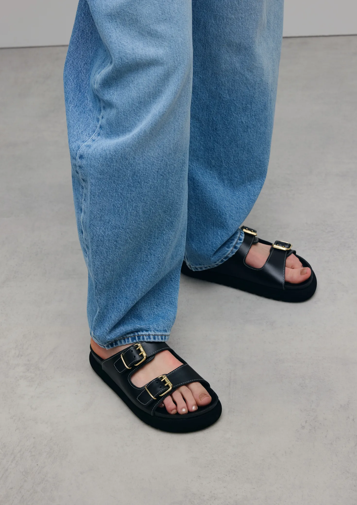 Zwarte leren slippers met goudkleurige buckles